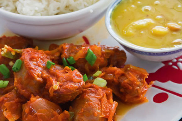 Rougail de saucisse, riz et sauce en assiette